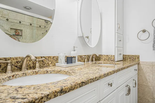 a bathroom with a granite countertop sink and a mirror