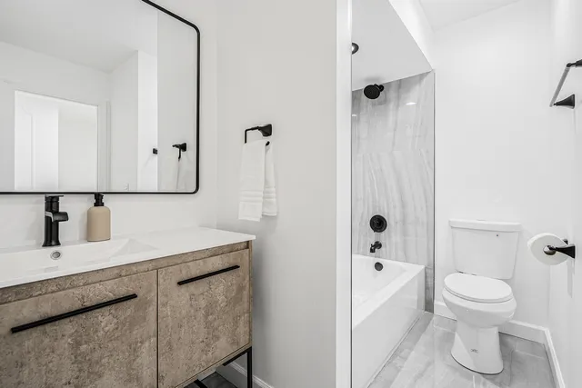 a bathroom with a sink toilet vanity and shower