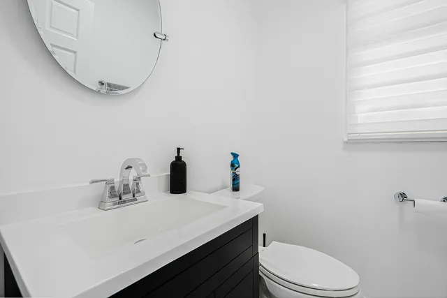a bathroom with a sink a toilet and mirror