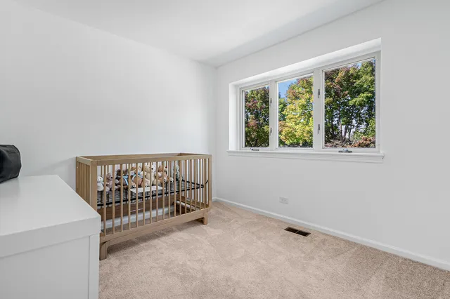 a bed sitting in a bedroom next to a window
