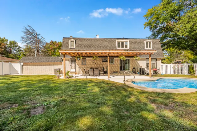 a view of a patio with table and chairs and couches with wooden floor and fence