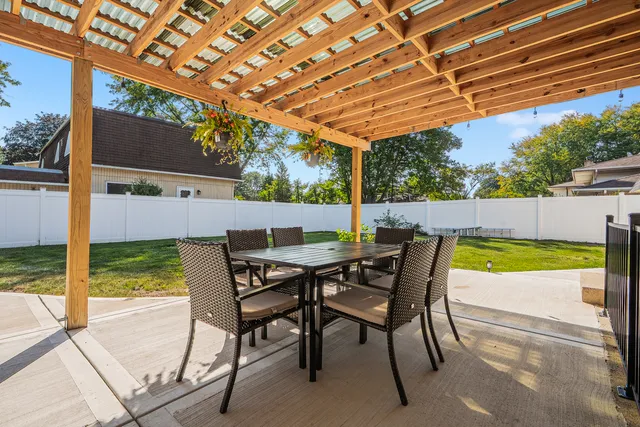 a view of a swimming pool with lawn chairs under an umbrella