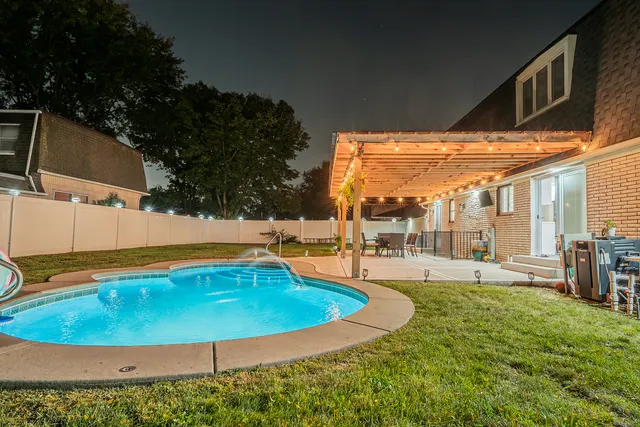 a swimming pool with outdoor seating and yard