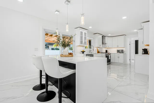 a kitchen with stainless steel appliances kitchen island granite countertop a table and chairs in it