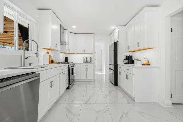 a kitchen with white cabinets and appliances