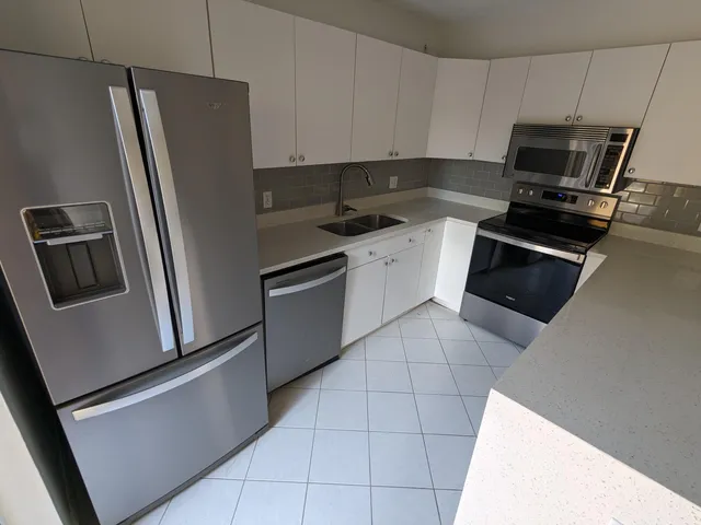 a kitchen with a refrigerator sink and microwave