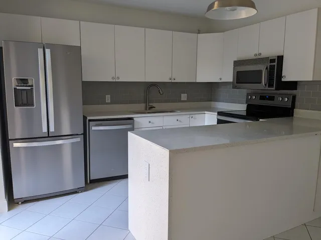 a kitchen with stainless steel appliances white cabinets and a refrigerator