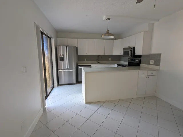 a kitchen with stainless steel appliances granite countertop a sink a stove a refrigerator and cabinets