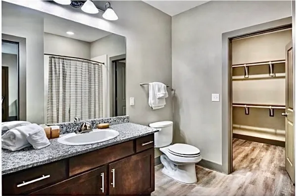 a bathroom with a granite countertop toilet sink and shower