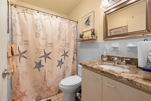 a bathroom with a granite countertop sink a toilet and a mirror