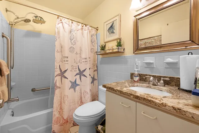 a bathroom with a granite countertop sink toilet and shower