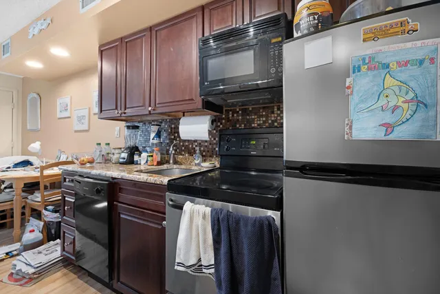 a kitchen with stainless steel appliances granite countertop a refrigerator and a stove top oven
