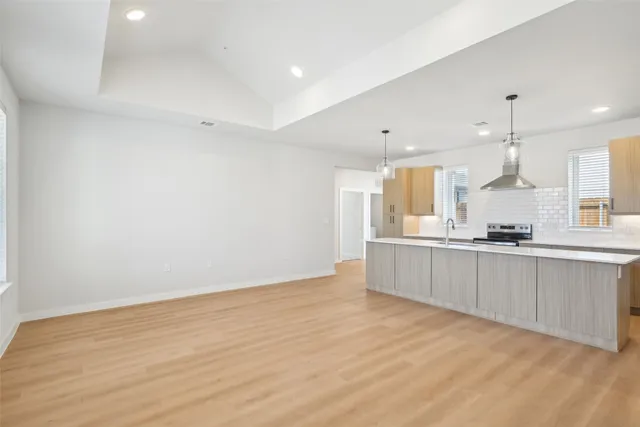 a large kitchen with a lot of counter space and wooden floor