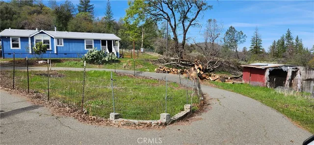 a view of a house with a yard and potted plants