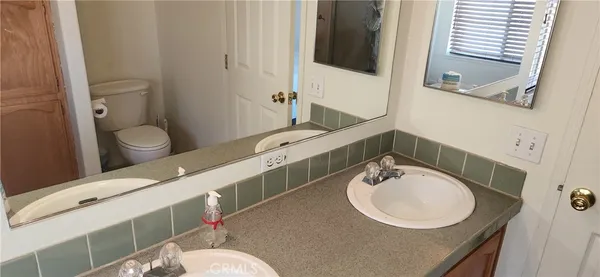 a bathroom with a granite countertop toilet sink and mirror