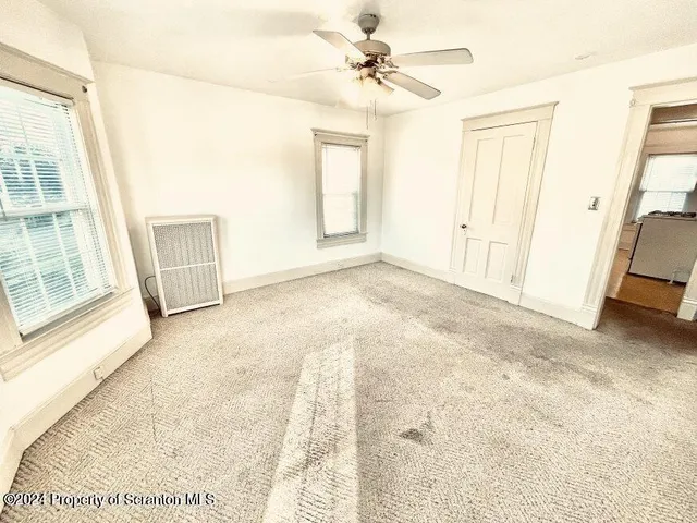 an empty room with windows and closet