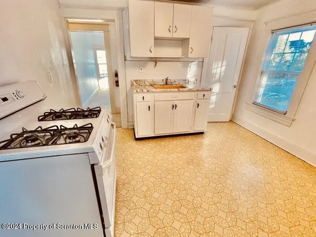 a kitchen with a stove a sink and a refrigerator