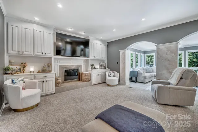 a living room with furniture a flat screen tv and a fireplace