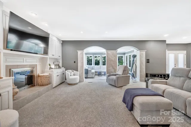 a living room with furniture a fireplace and a flat screen tv