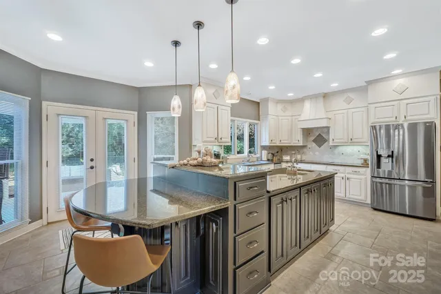 a kitchen with kitchen island a sink stainless steel appliances and cabinets