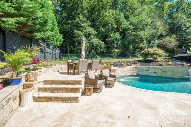 a view of a patio with couches and chairs under an umbrella