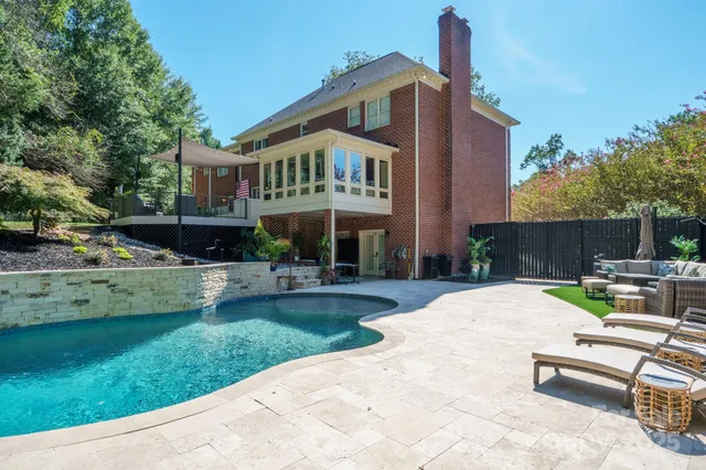 a view of swimming pool with chairs and garden
