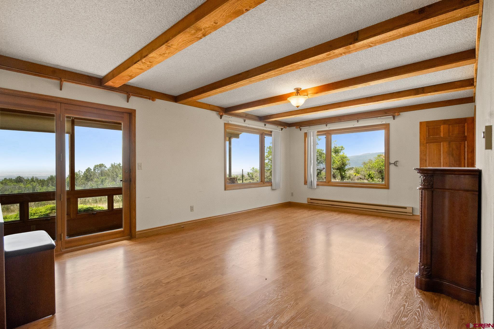21565 Highway 65 Cedaredge, CO 81413 - Photo 12 of 42 a view of an empty room with wooden floor and a window
