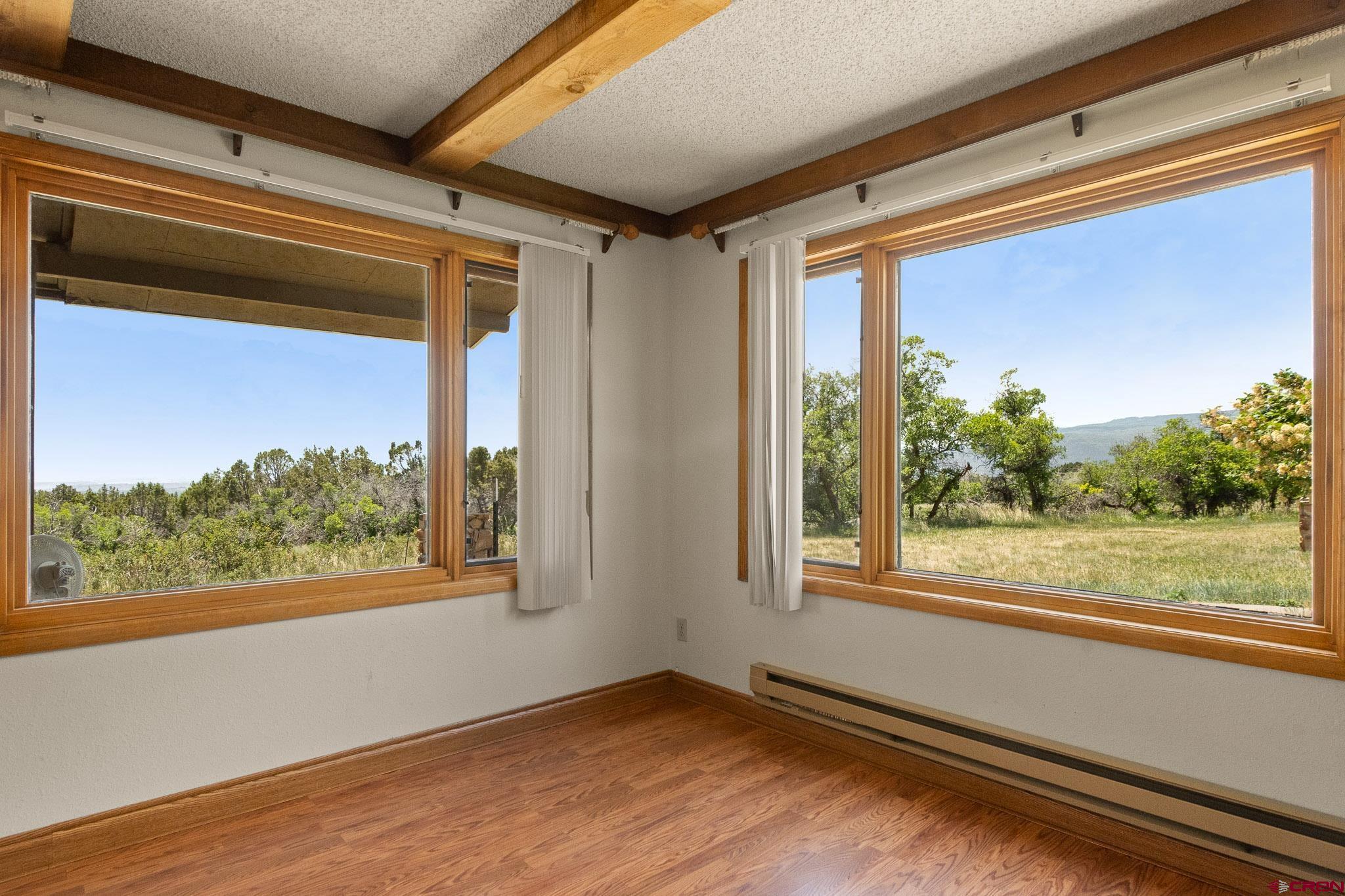 21565 Highway 65 Cedaredge, CO 81413 - Photo 14 of 42 a view of an empty room with wooden floor and a window