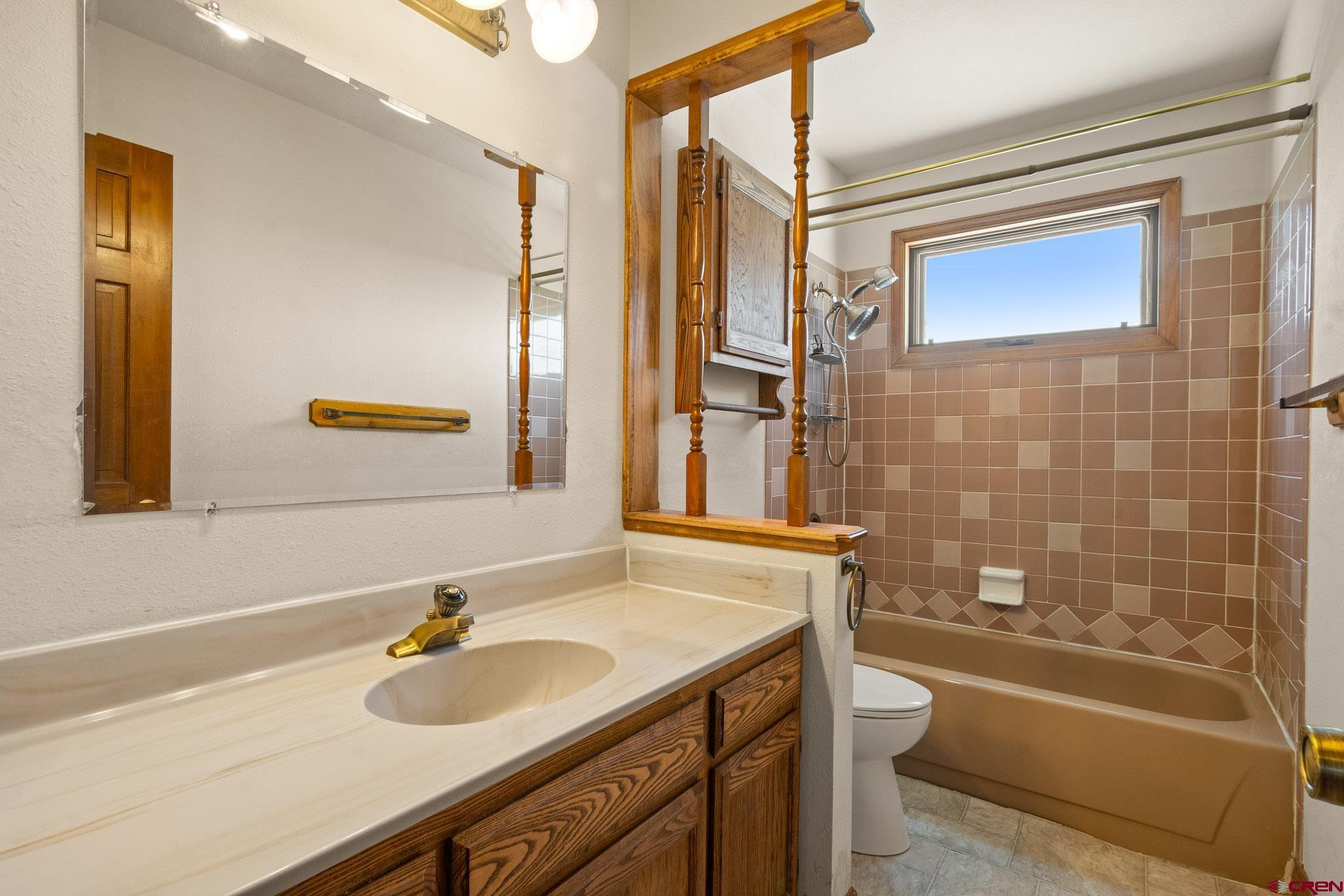 21565 Highway 65 Cedaredge, CO 81413 - Photo 25 of 42 a bathroom with a granite countertop sink toilet and shower