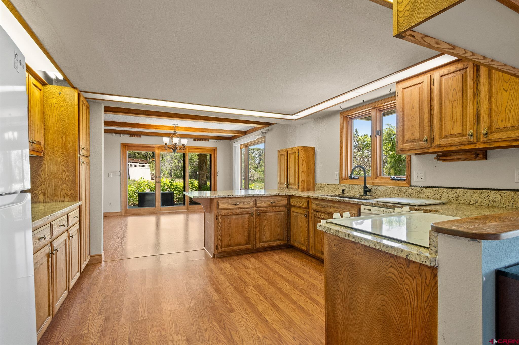 21565 Highway 65 Cedaredge, CO 81413 - Photo 9 of 42 a kitchen with stainless steel appliances granite countertop a stove and a wooden floors