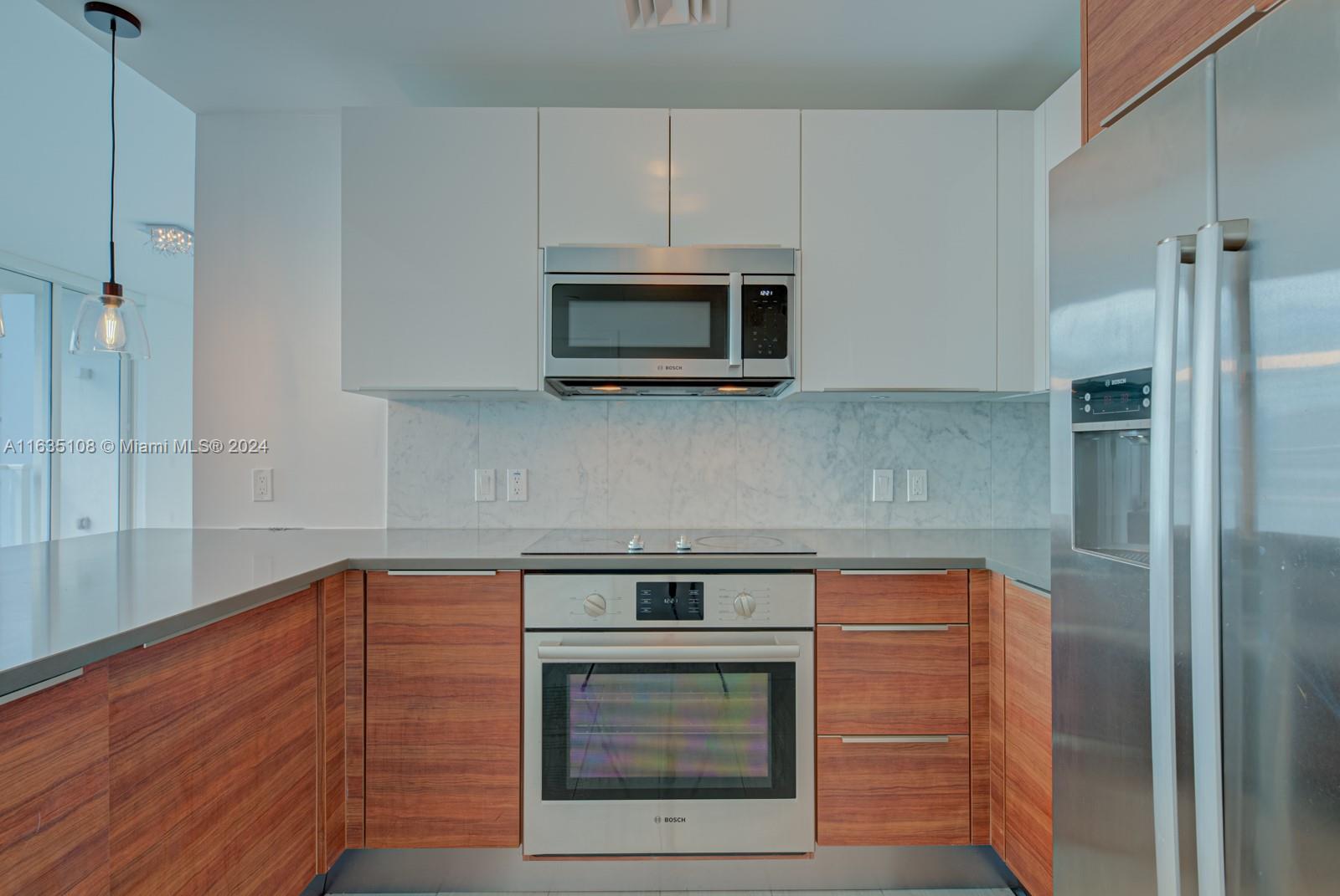 601 Northeast 27th Street, Unit 1502 Miami, FL 33137 - Photo 5 of 61 a kitchen with stainless steel appliances a stove and a microwave