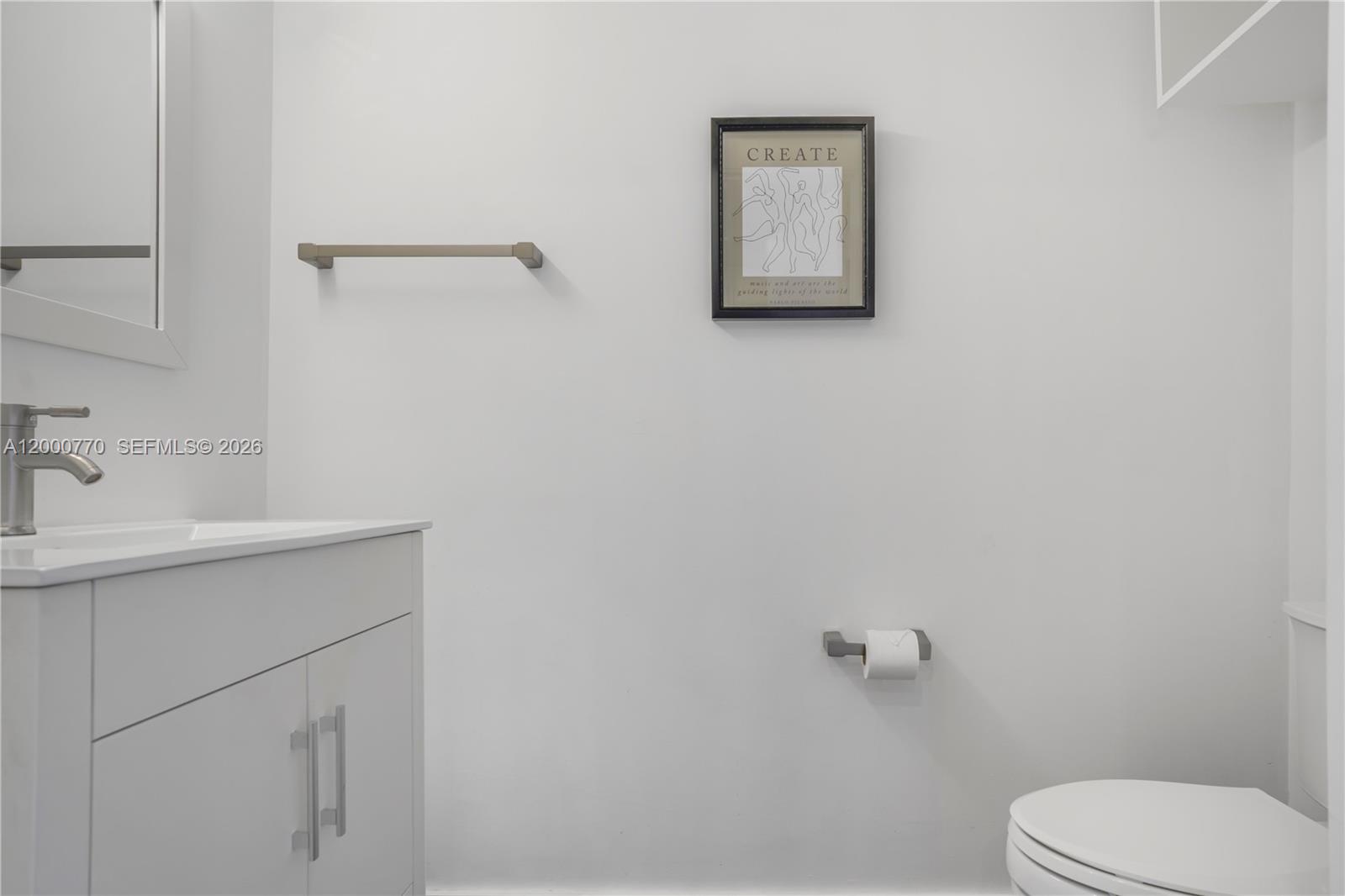 3339 Virginia Street, Unit 339 Miami, FL 33133 - Photo 11 of 24 a bathroom with a toilet sink vanity and mirror