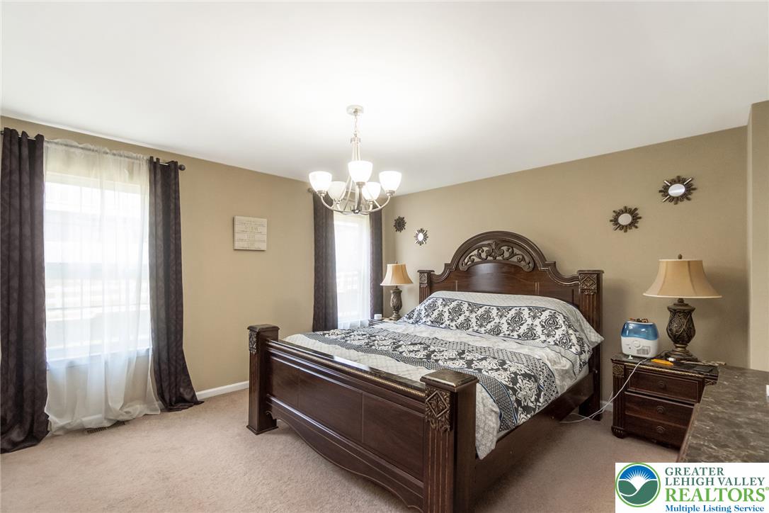 3566 Penfield Way Nazareth, PA 18064 - Photo 39 of 47 Well-lit Primary Bedroom featuring elegant crown molding and a decorative overhead light fixture.