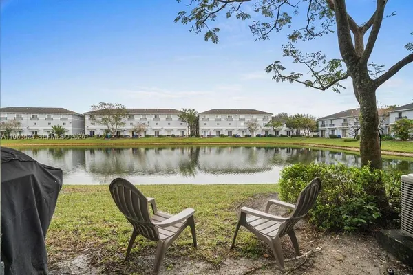 a view of a lake with a bench under an umbrella
