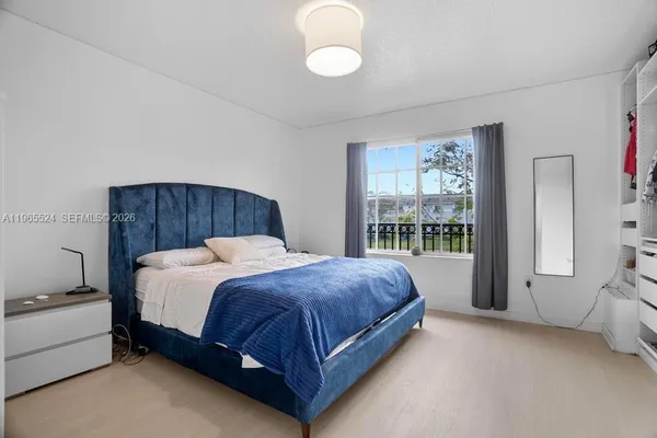 a spacious bedroom with a bed and a large window