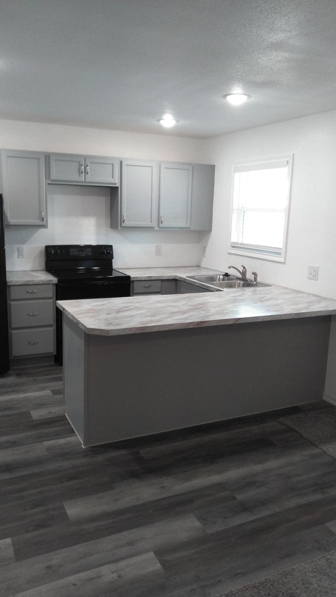 1101 14th Street Lubbock, TX 79401 - Photo 7 of 19 a kitchen with stainless steel appliances granite countertop a sink and a stove