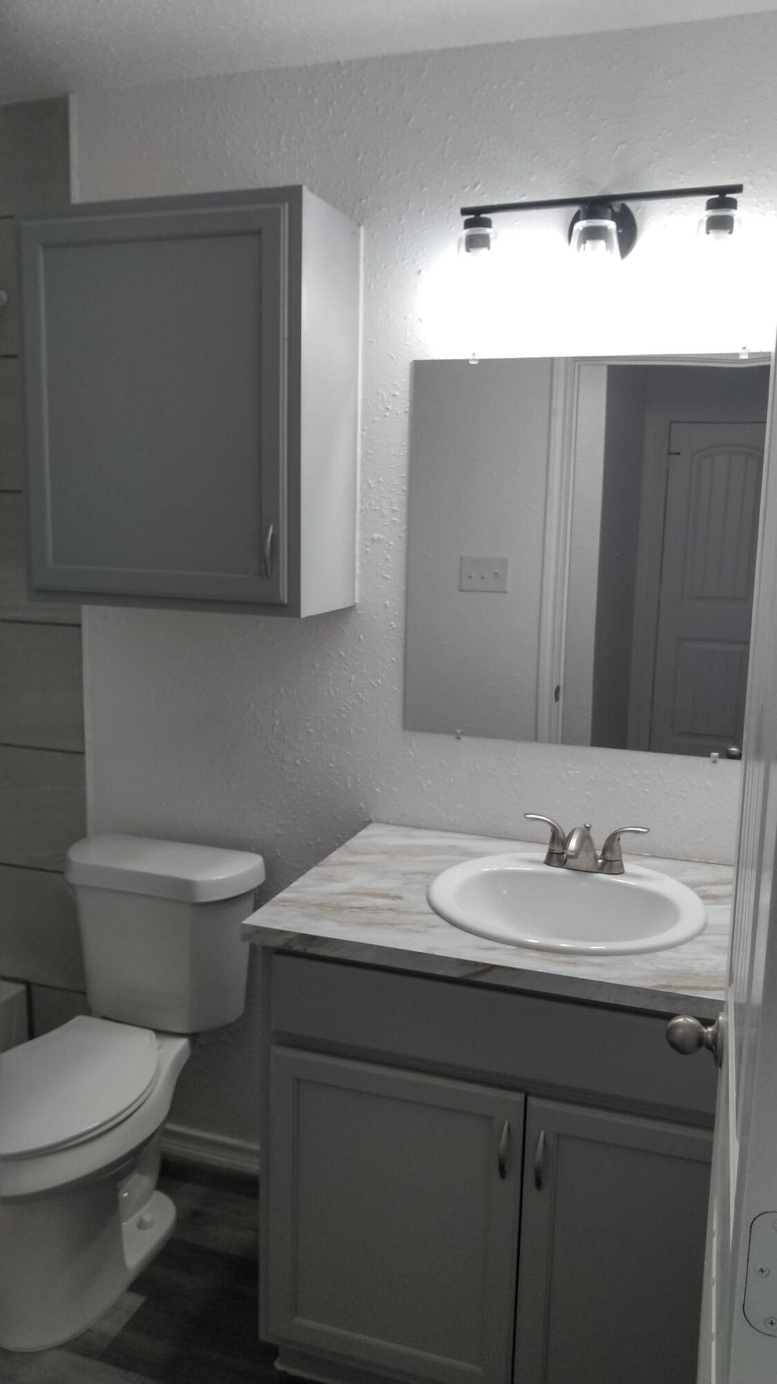 1101 14th Street Lubbock, TX 79401 - Photo 8 of 19 a bathroom with a sink and a toilet