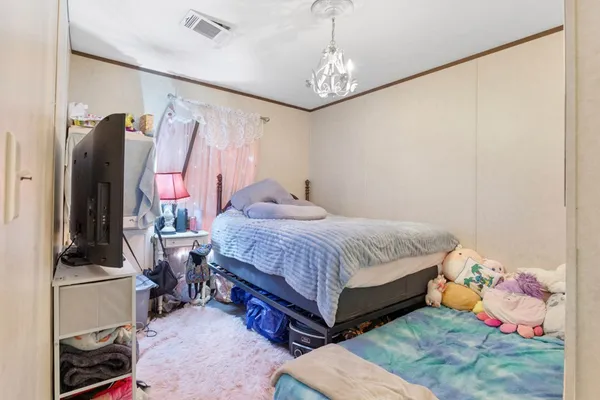 a bedroom with a bed and a chandelier