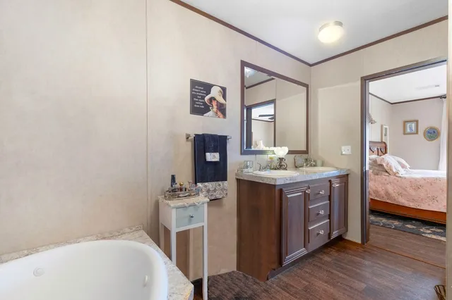 a spacious bathroom with a tub sink and mirror