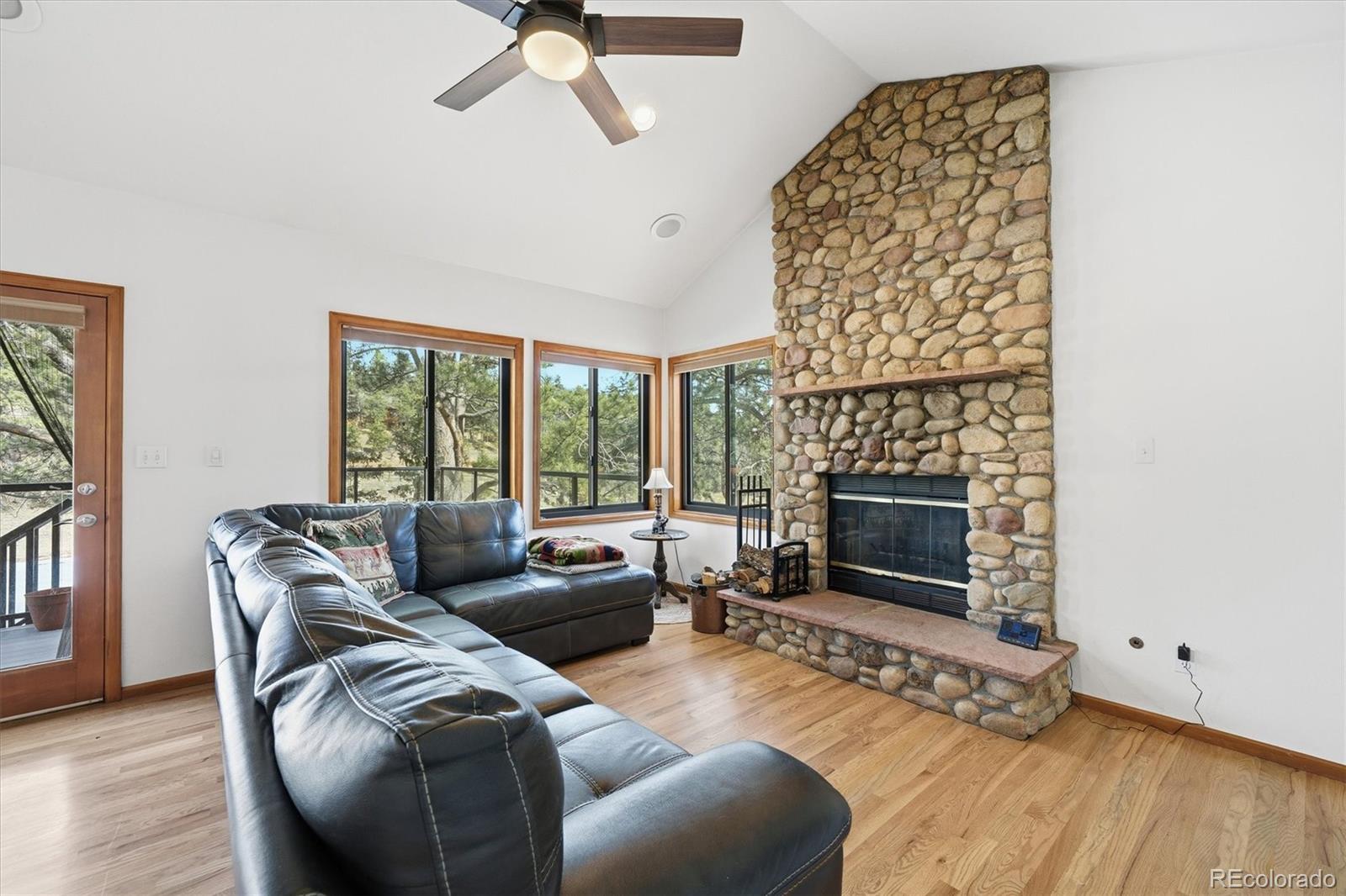 2565 Nova Road Pine, CO 80470 - Photo 11 of 50 a living room with furniture a fireplace and a floor to ceiling window