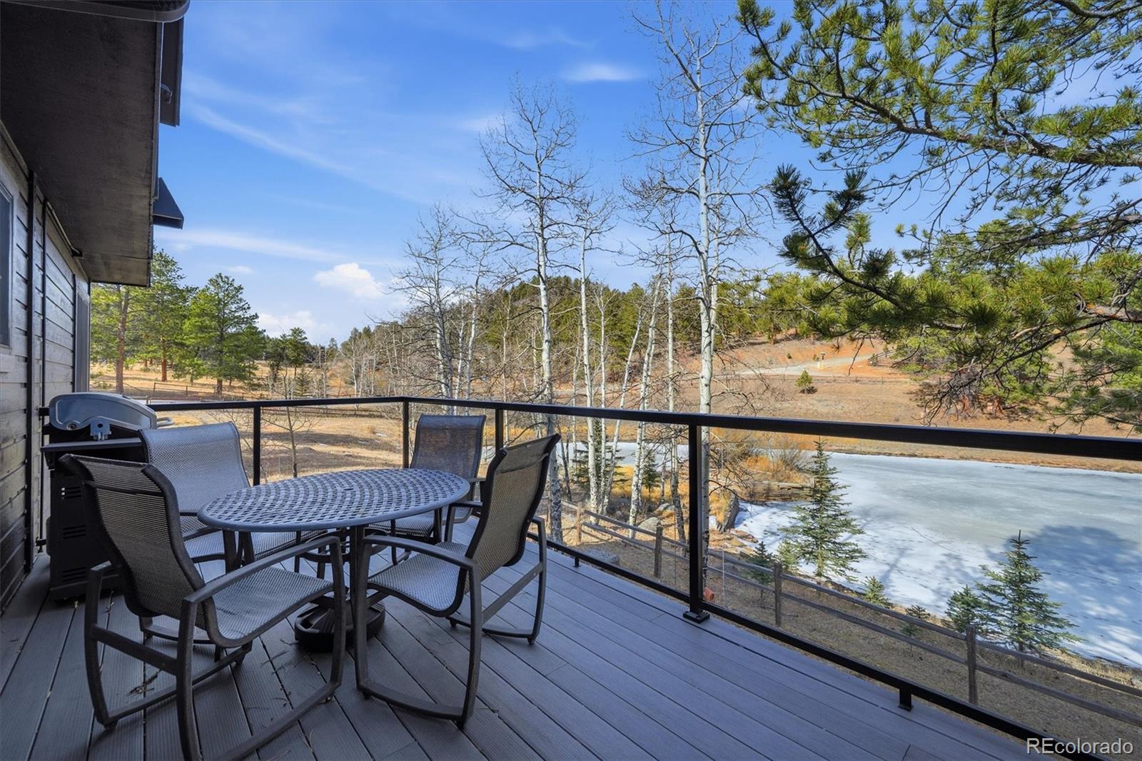 2565 Nova Road Pine, CO 80470 - Photo 16 of 50 a view of a chairs and table on the wooden deck