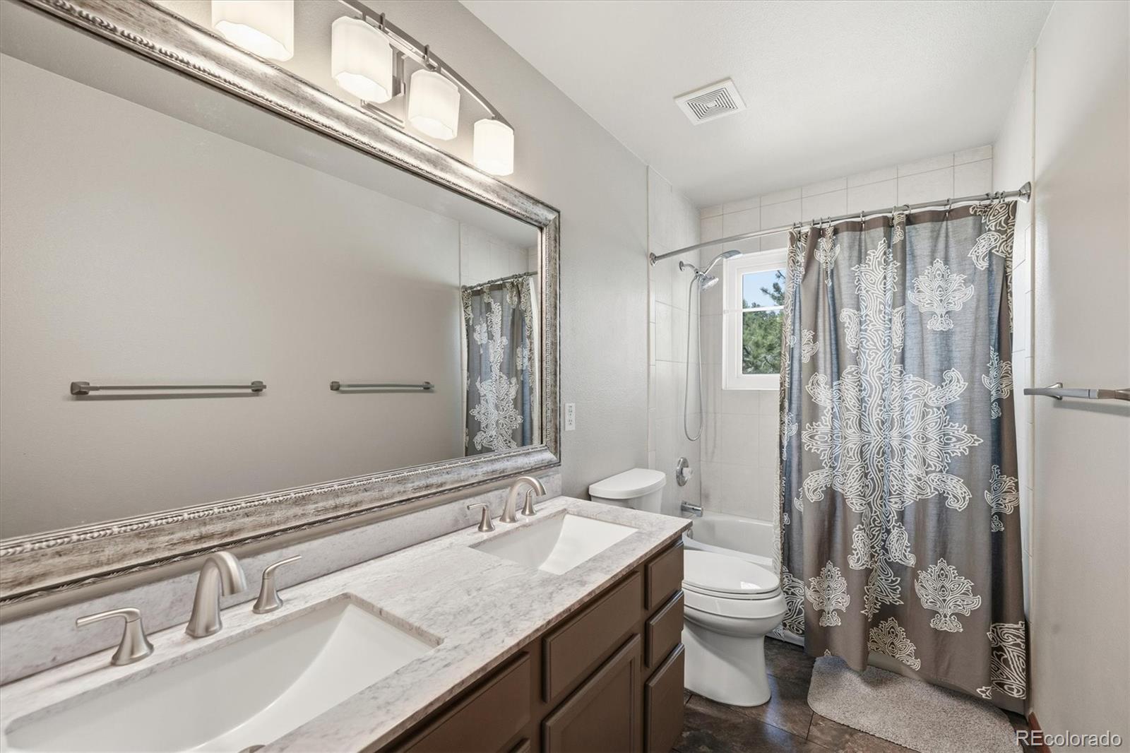 2565 Nova Road Pine, CO 80470 - Photo 26 of 50 a bathroom with a granite countertop sink a toilet a mirror and shower