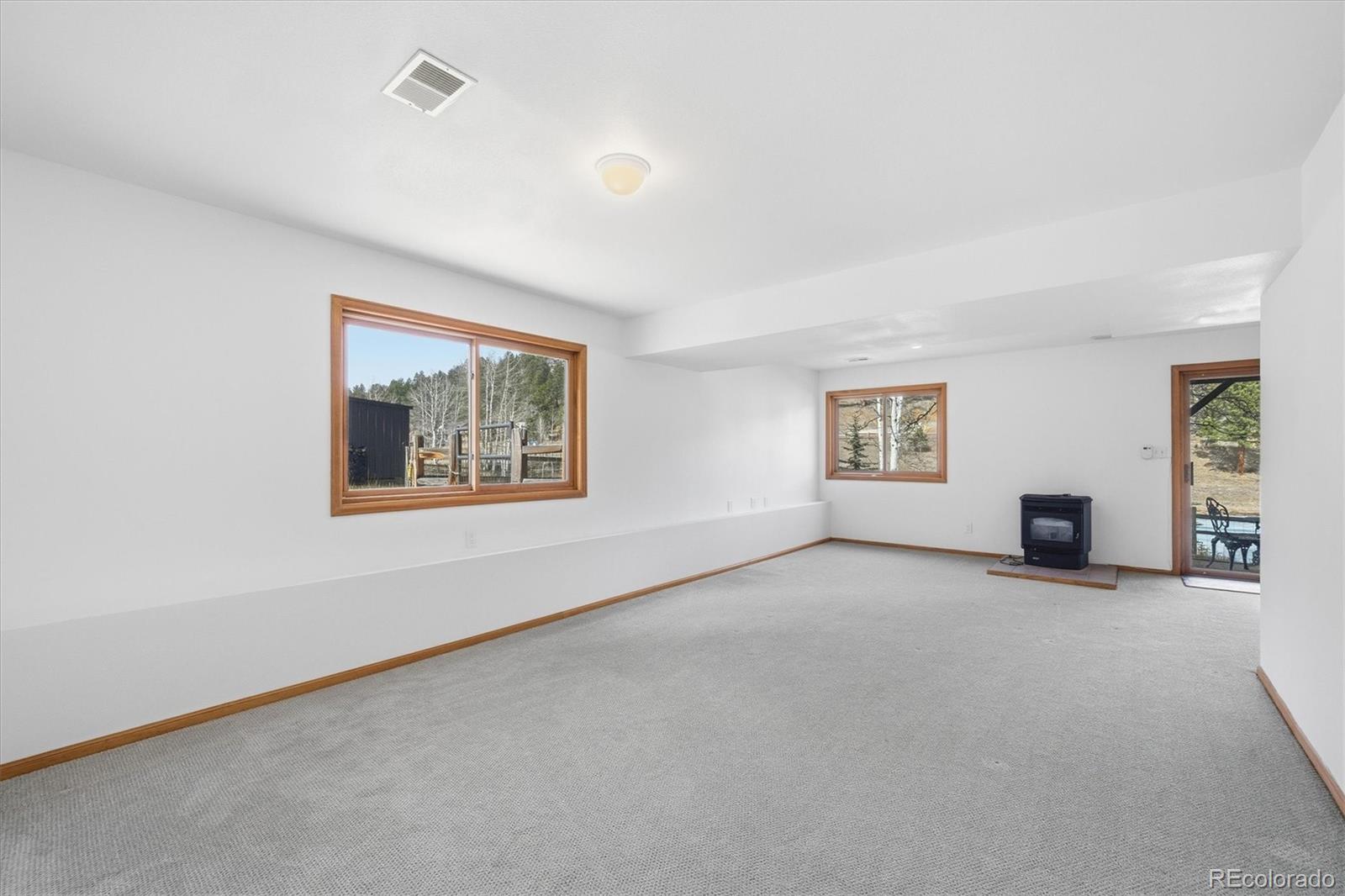 2565 Nova Road Pine, CO 80470 - Photo 31 of 50 an empty room with windows and fireplace