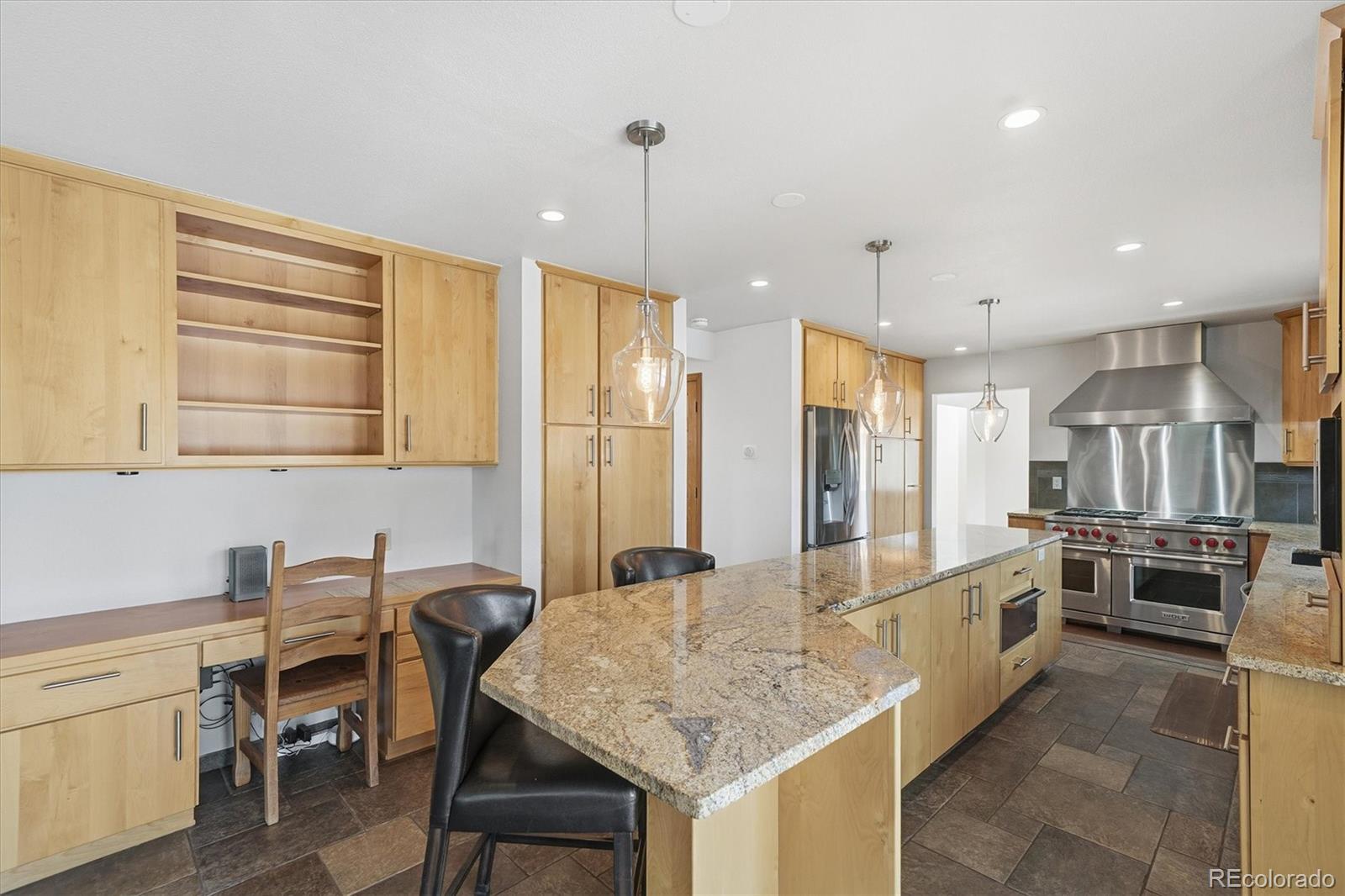 2565 Nova Road Pine, CO 80470 - Photo 9 of 50 a kitchen with kitchen island granite countertop a table chairs sink and cabinets