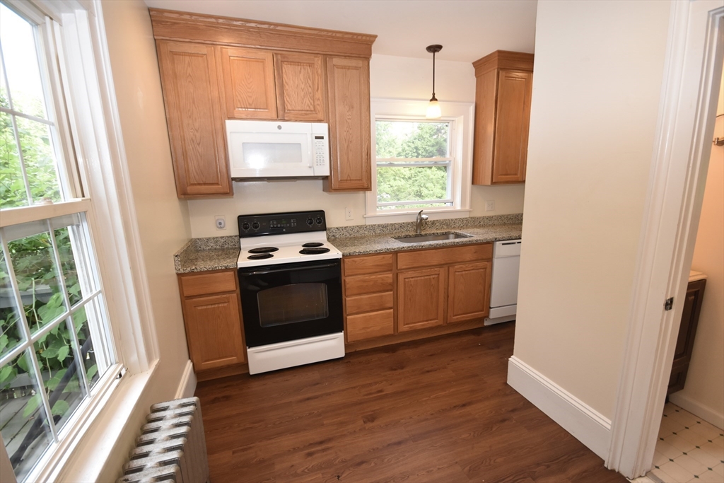 487 Main Street Amherst, MA 01002 - Photo 13 of 39 a kitchen with a stove a sink and a window