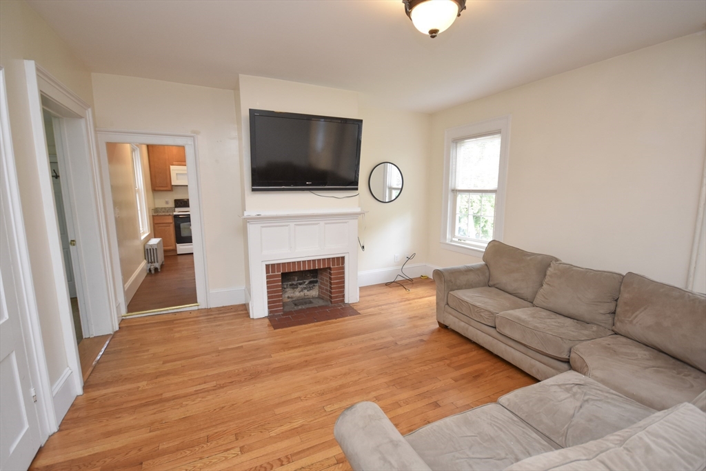 487 Main Street Amherst, MA 01002 - Photo 6 of 39 a living room with furniture a fireplace and a flat screen tv
