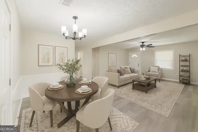 a living room with furniture a chandelier and a dining room