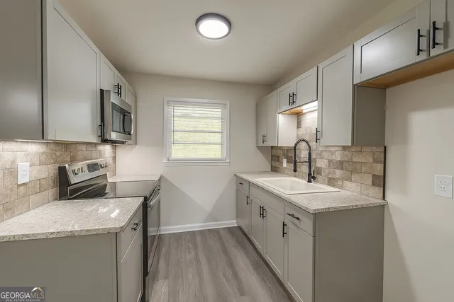 a kitchen with a sink stove top oven and microwave