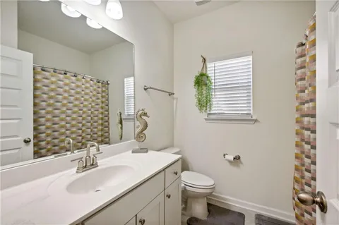 a bathroom with a sink a toilet and shower curtain