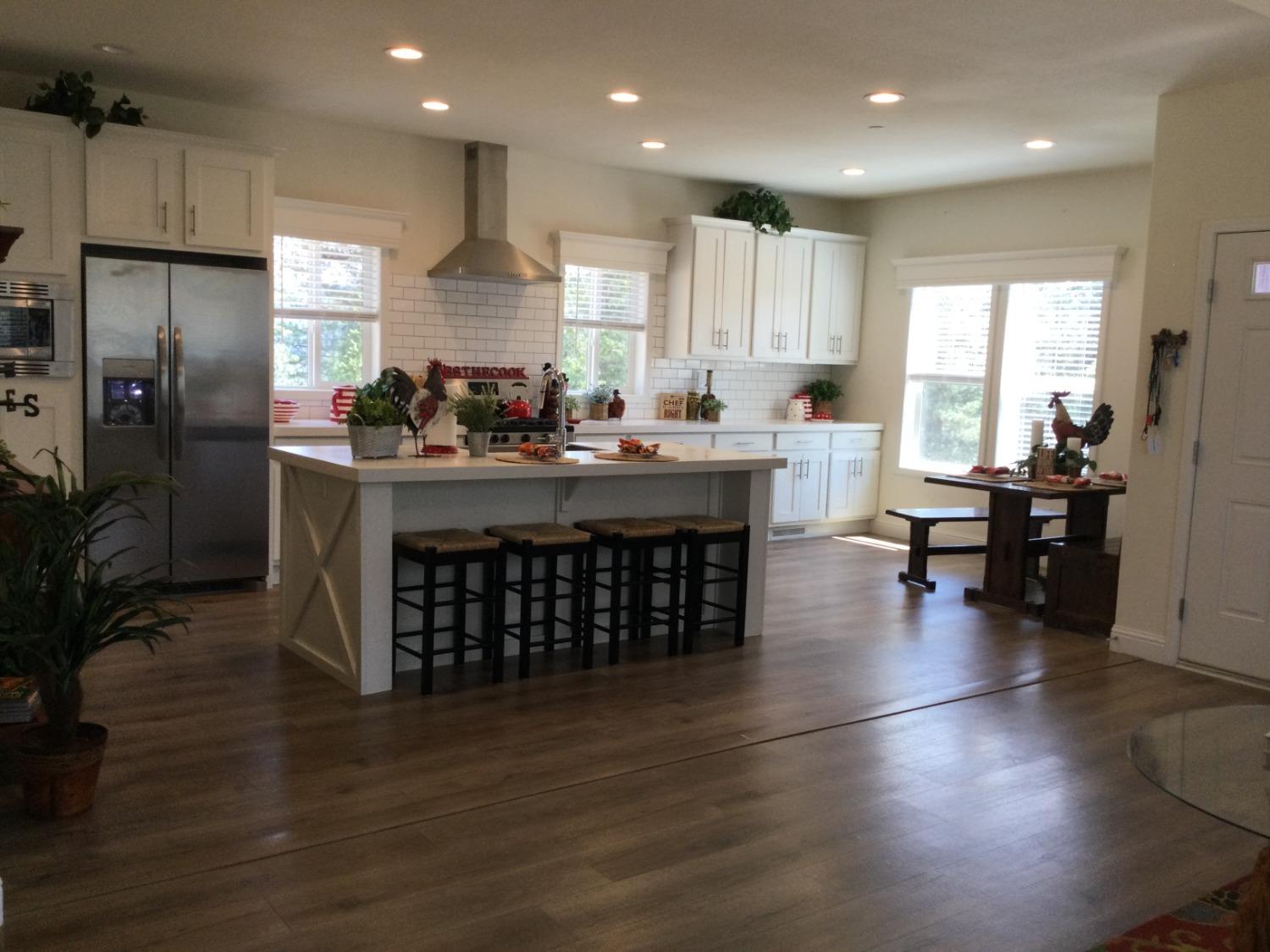 5110 Sly Park Road Pollock Pines, CA 95726 - Photo 76 of 86 a kitchen with stainless steel appliances granite countertop a stove a sink dishwasher a refrigerator and white cabinets with wooden floor